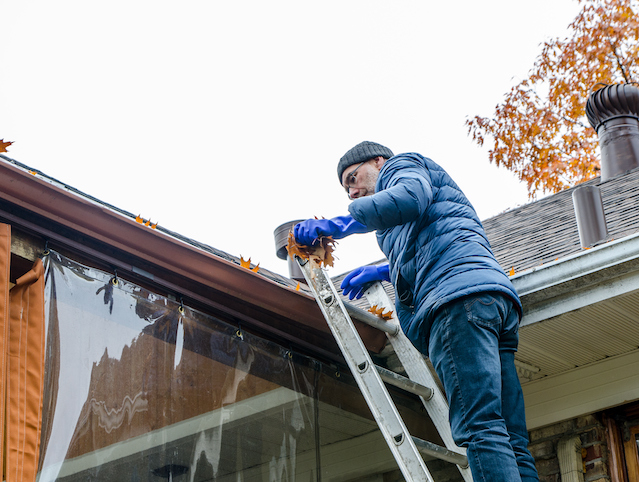 climbing ladder to removing leaves from gutter